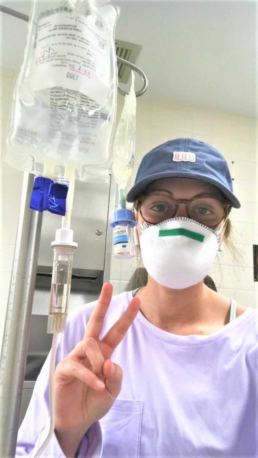 young woman battling chronic migraine at the hospital receiving IV fluids