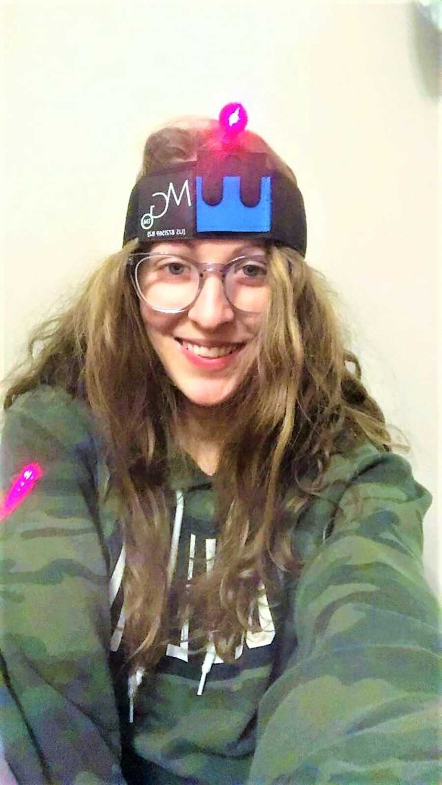 young woman battling chronic migraine wearing glasses and a headband