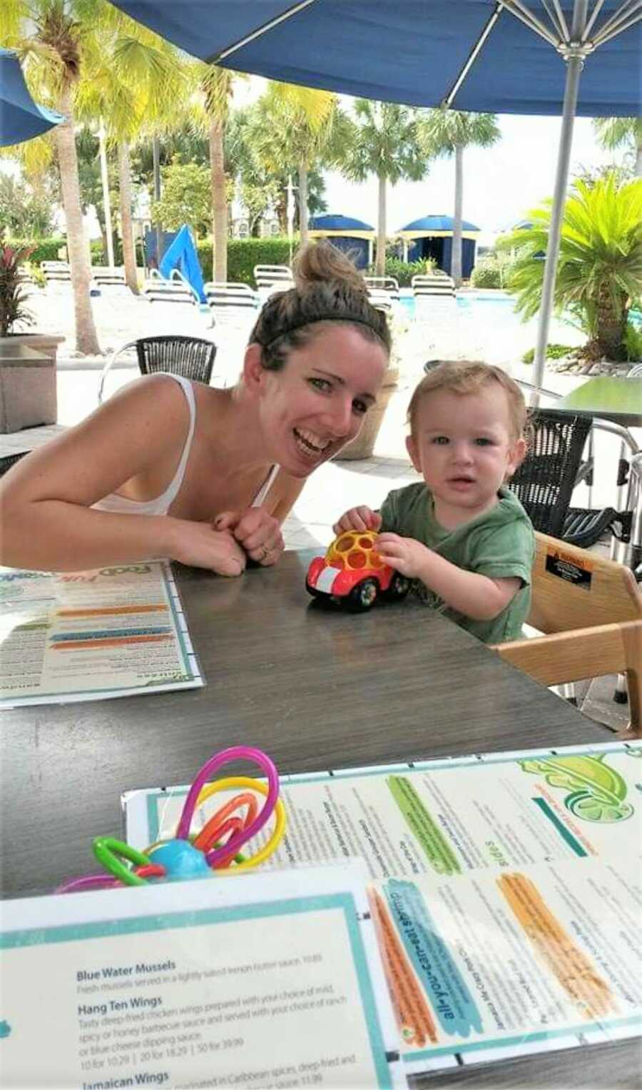 OCD mom smiling with toddler at an outdoor dinning table 