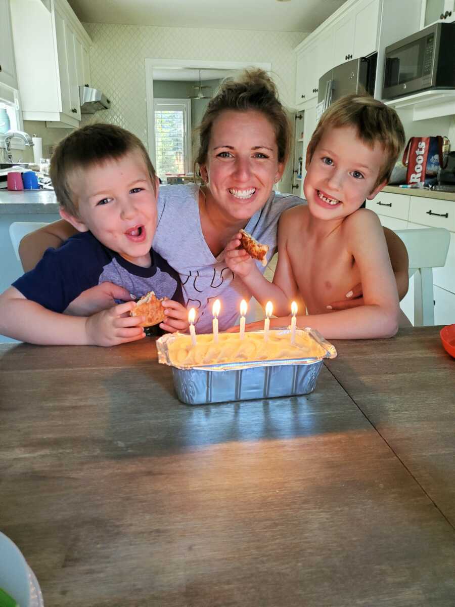 Mom diagnosed with OCD sitting with her two sons at the dinning table with a cake and candles 