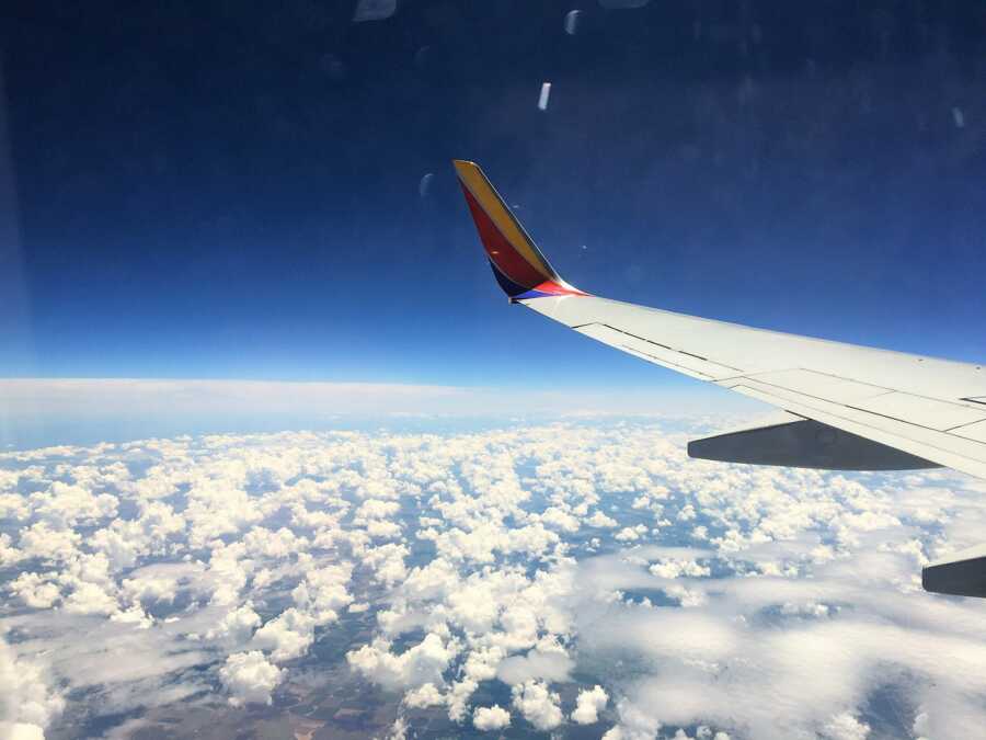 window view of Southwest Airline airplane flying among the clouds showing the right wing