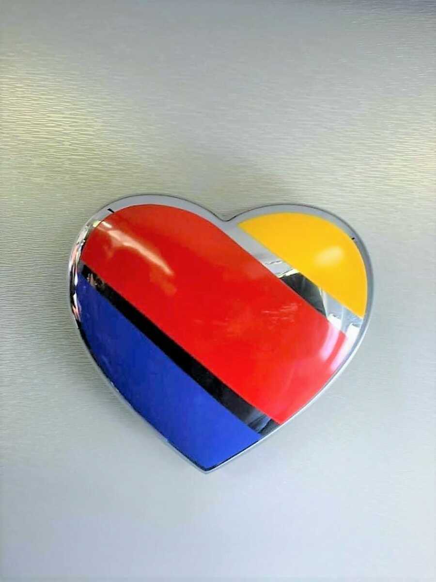 Pin shaped like a heart colored in yellow her and blue representing the colors of Southwest Airlines 