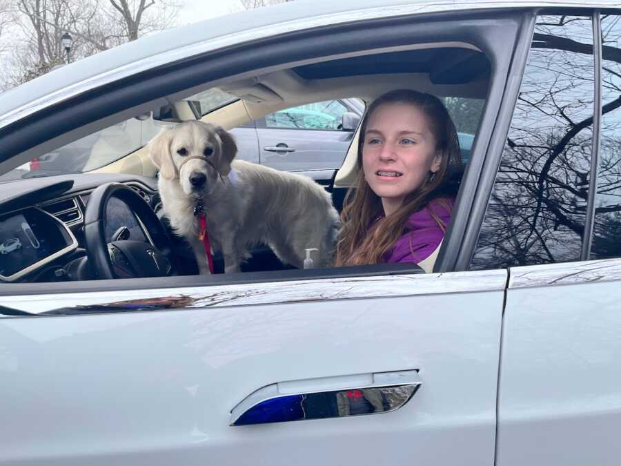 little girl with her dog in a tesla
