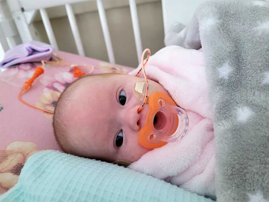 Rainbow baby with Down Syndrome on a crib at NICU due to heart problems