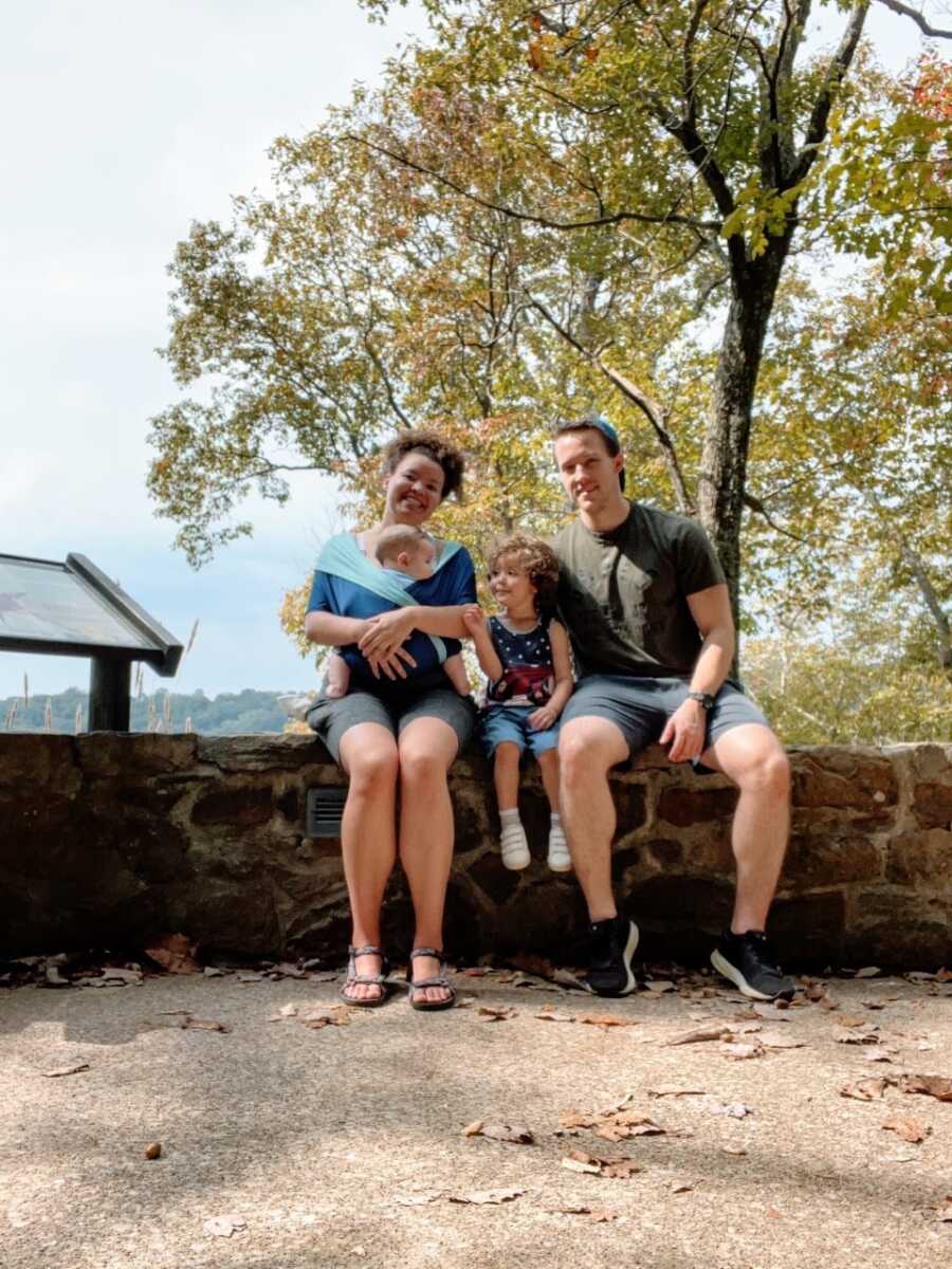 Family of four take a group photo together while on vacation