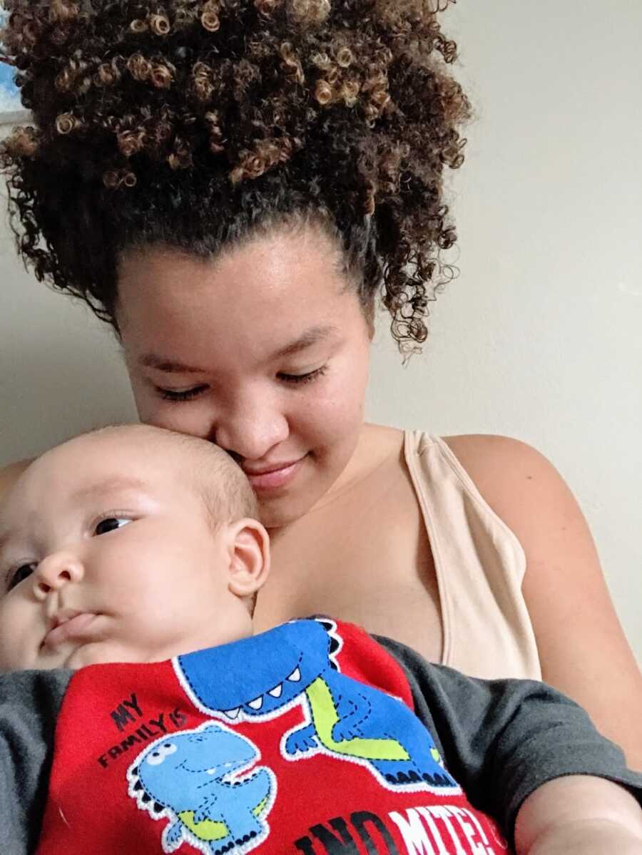 Mom snuggles with her son while he lays in her lap