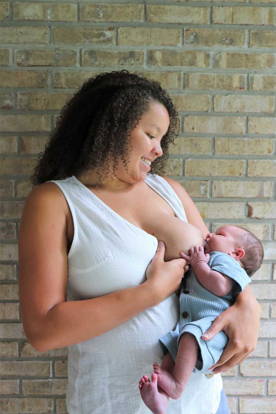postpartum mom breastfeeding newborn outside