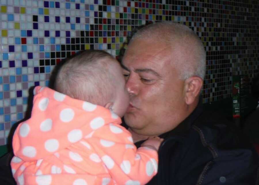 man giving baby girl a kiss who he cared for