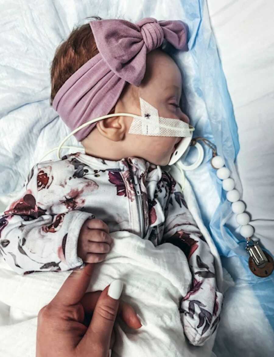 little girl laying in bed with her feeing tube