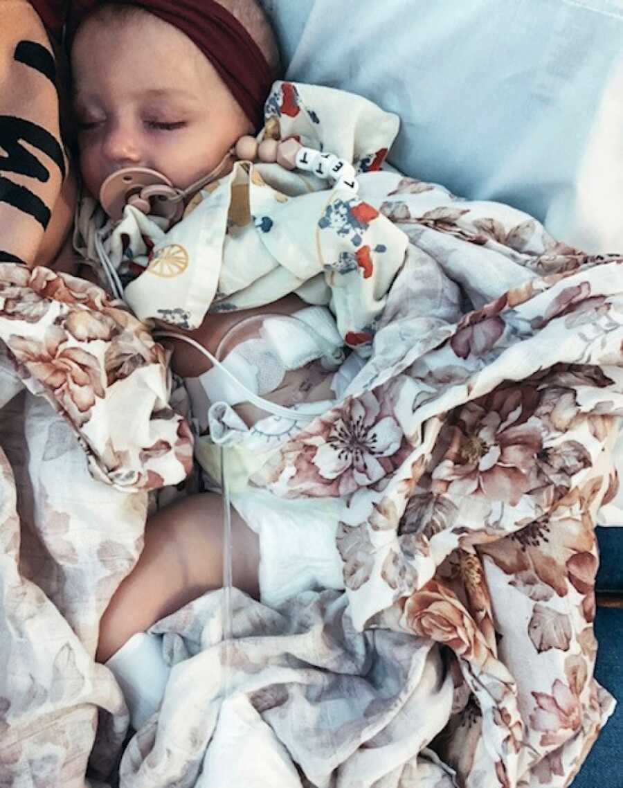 little girl laying down with her feeding tube