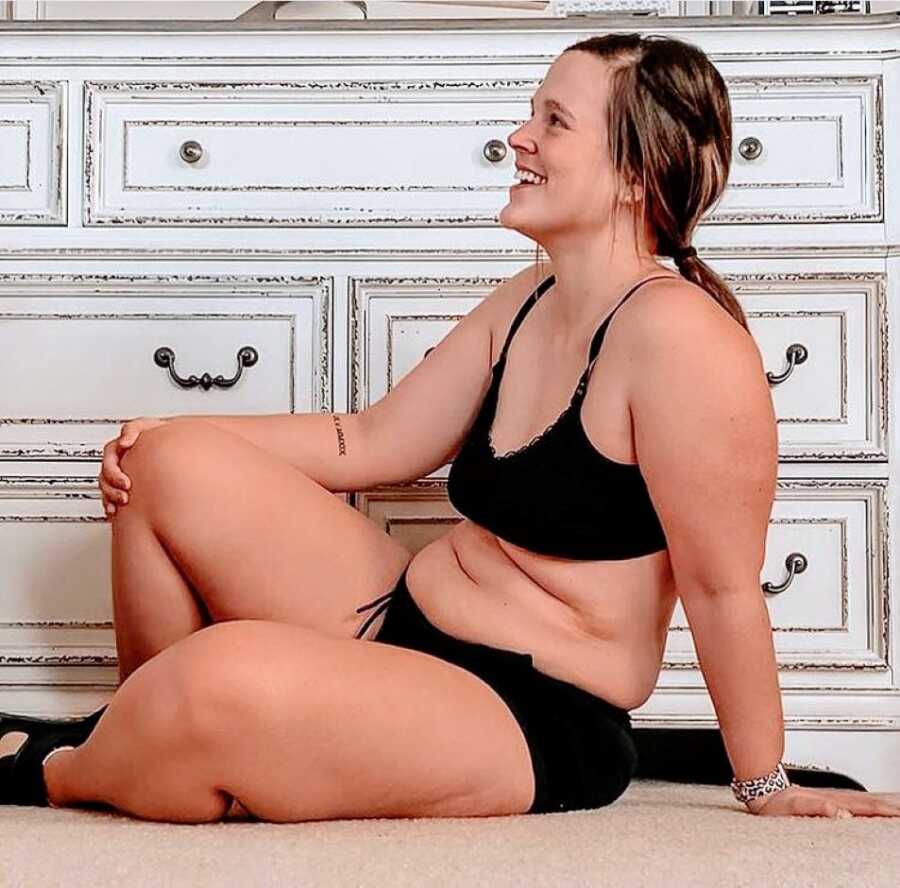 Mom smiles while embracing her natural body in black undergarments