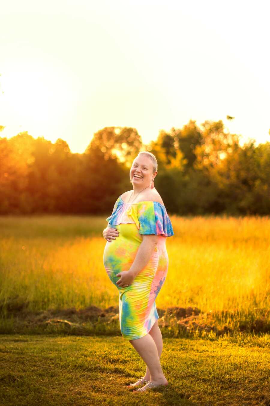 woman taking a pregnancy picture with the sun