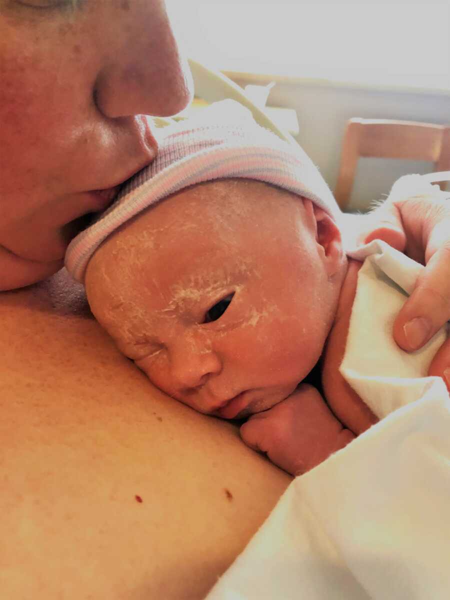 woman holding her new born daughter after birth