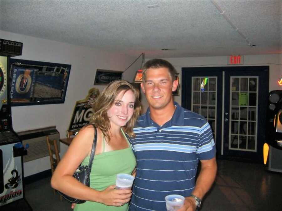 couple at a party holding drinks on their hands during their first year of dating before getting married 