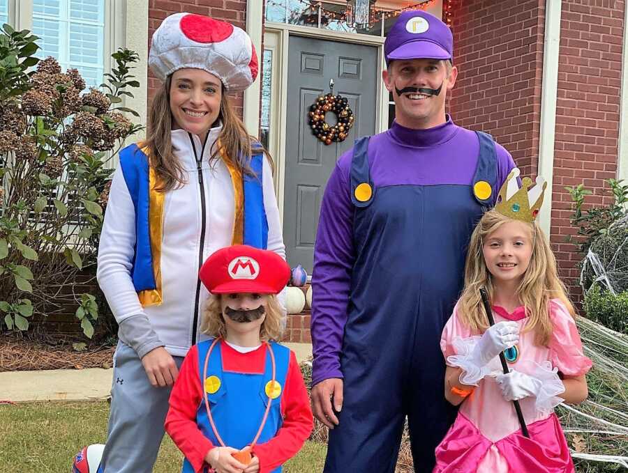 divorced couple wearing matching Mario Halloween costumes with their two kids 