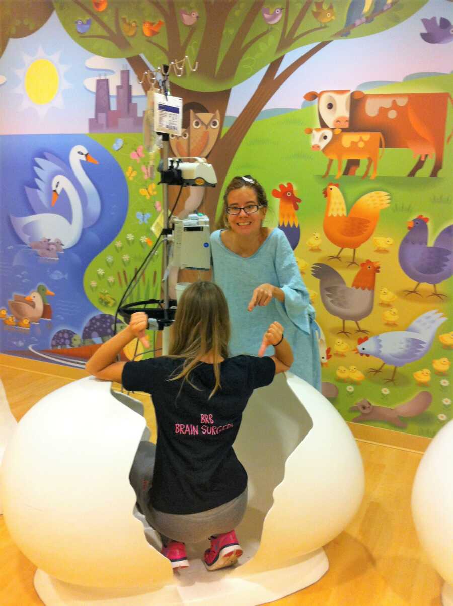 Woman with rare chronic disease recovering from brain surgery with the brain surgeon sitting on a giant egg shell