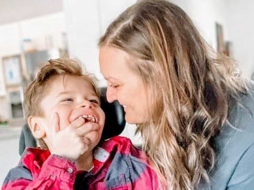 Special needs mom smiles at her son while he smiles back at her