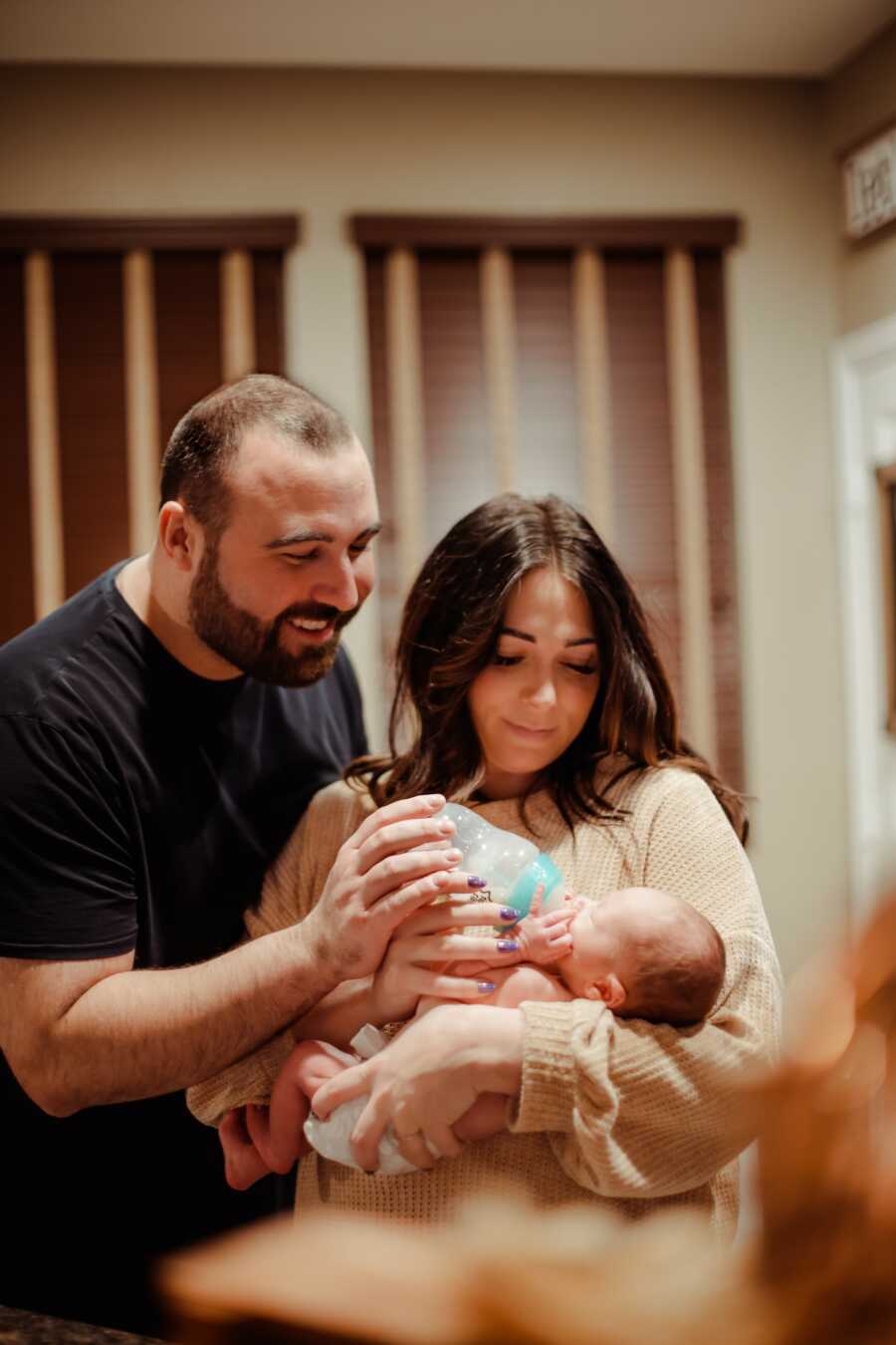 mom and dad feeding their new born