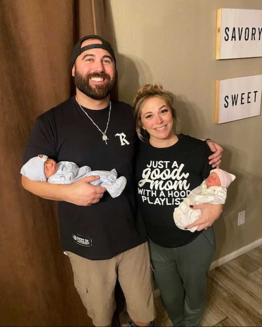 mom and dad holding their born twins