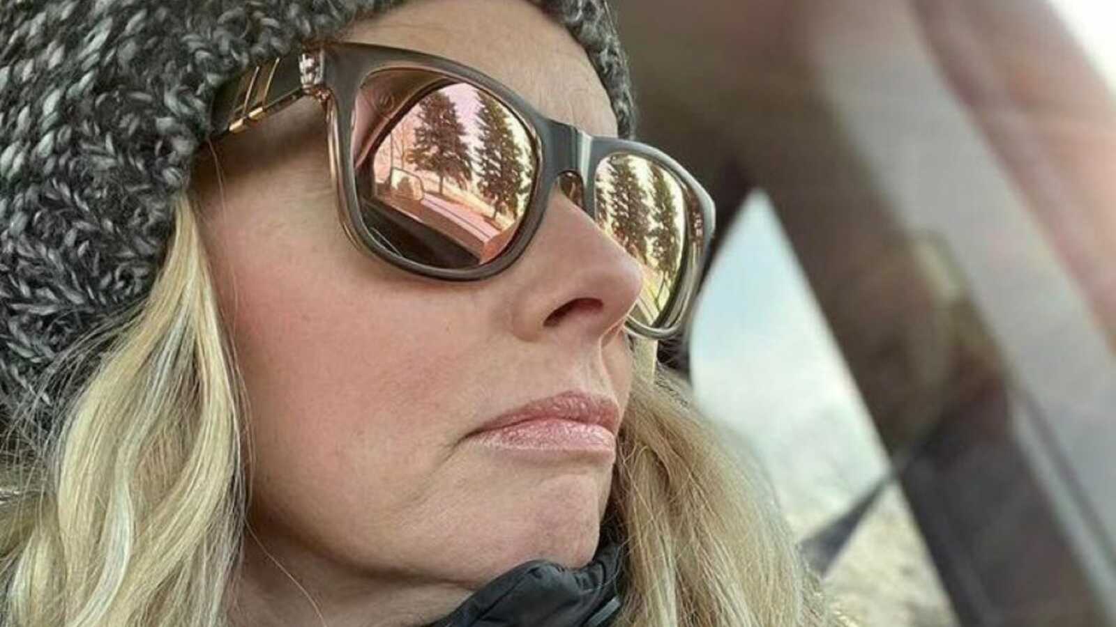 Woman reflecting on life's journey takes a moody selfie in the car