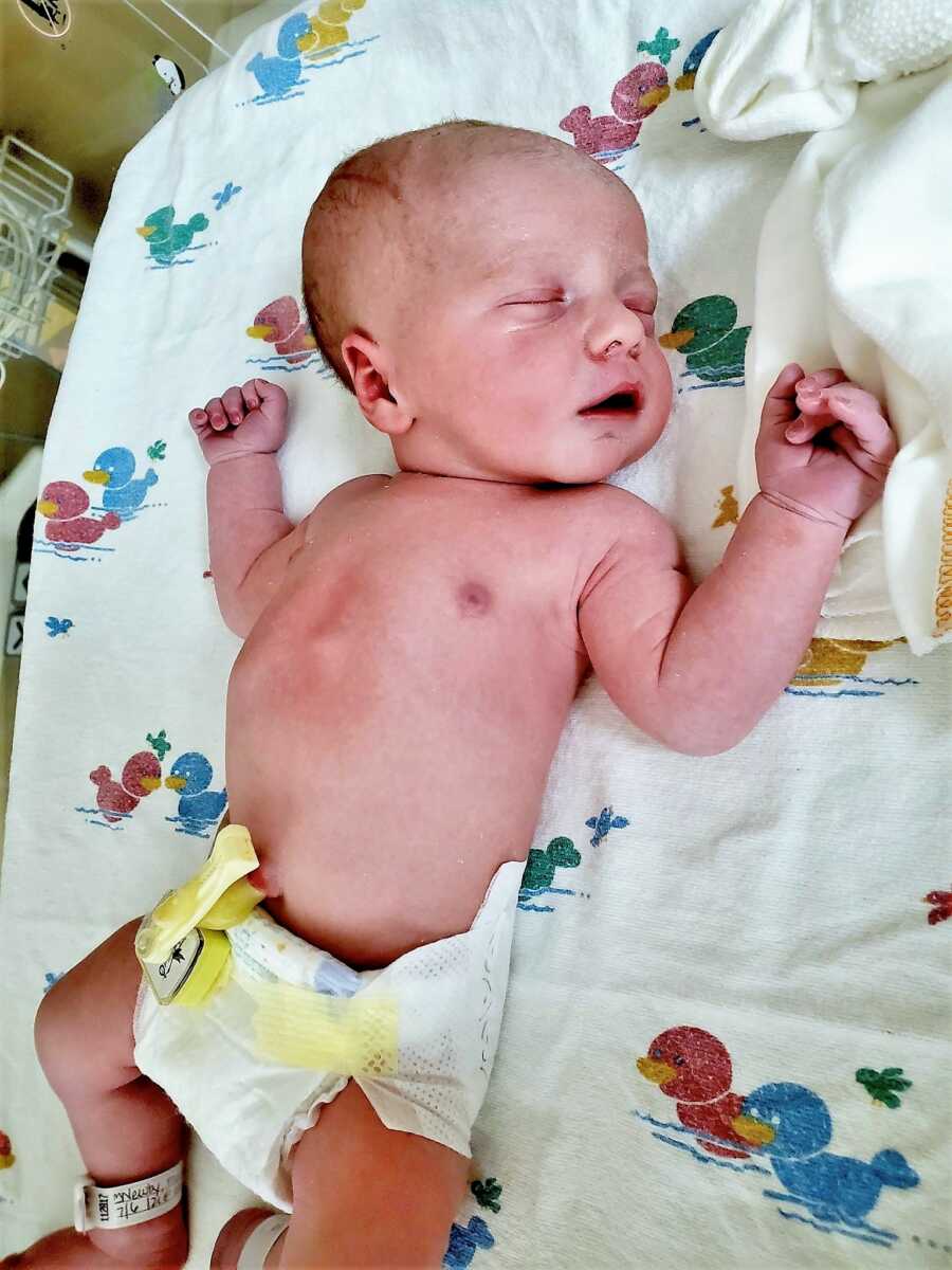 Newborn rainbow baby sleeping at the hospital shortly after birth 