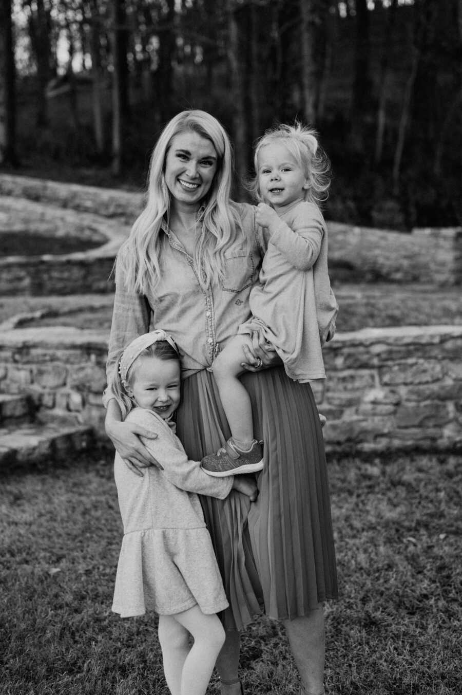 Mom smiles during family photoshoot with her two daughters