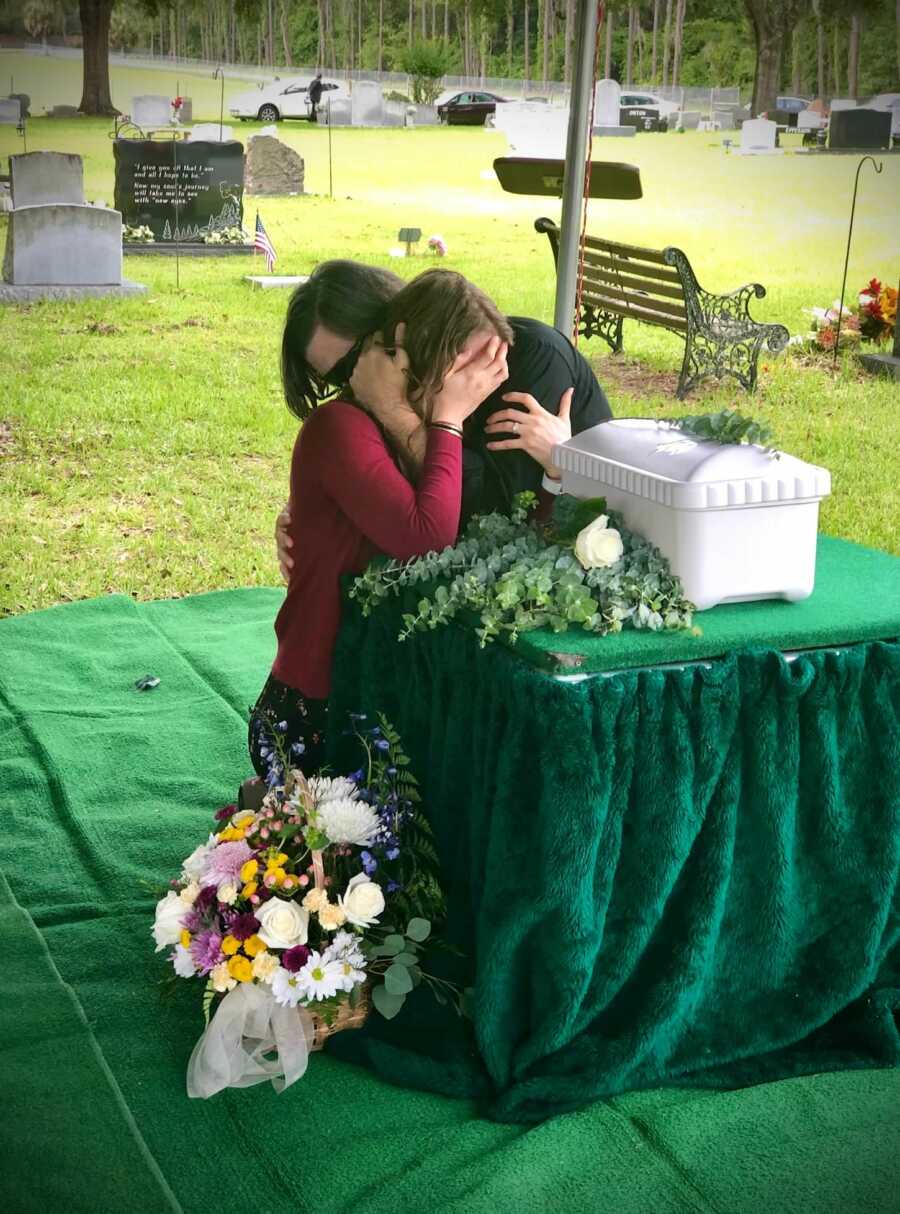 husband and wife crying at their son's casket