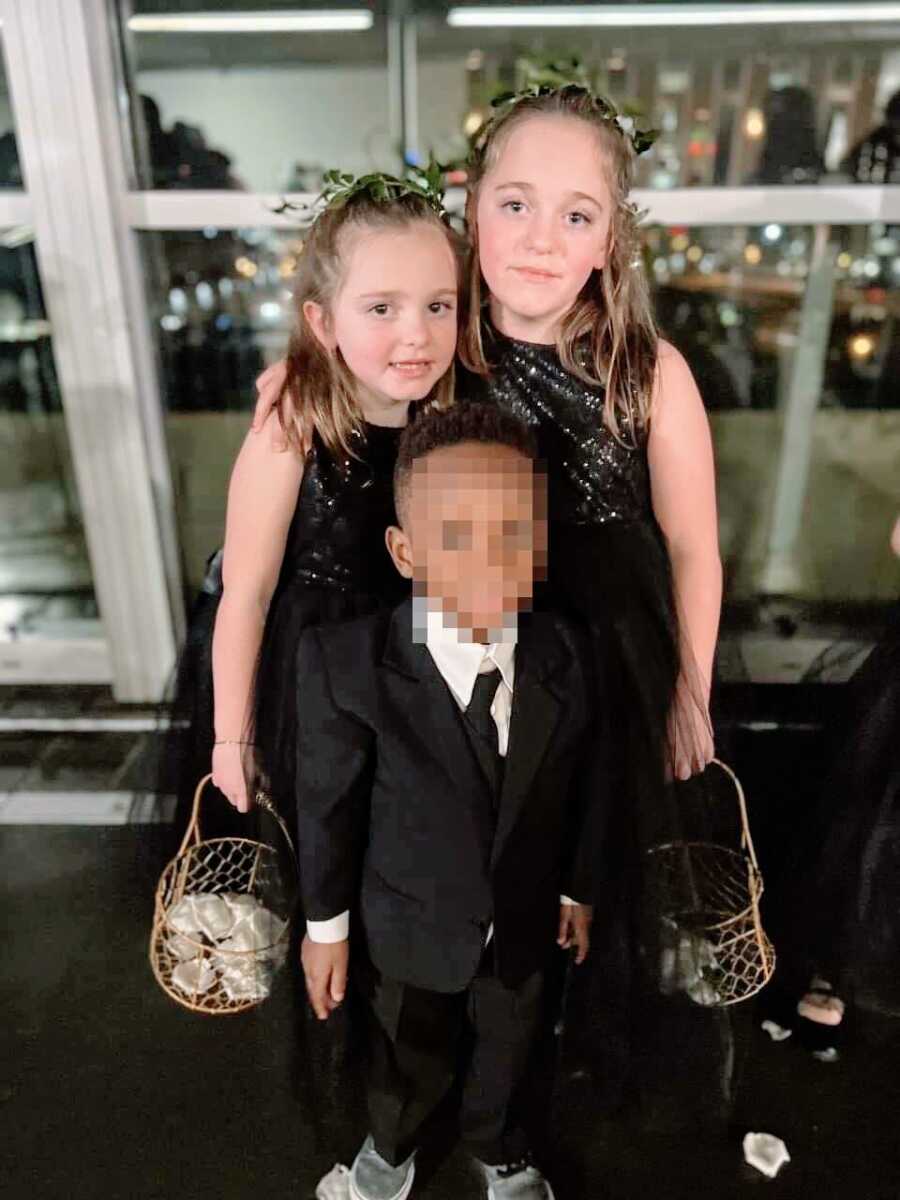 Mom snaps a photo of her two biological daughters and foster son, all wearing black