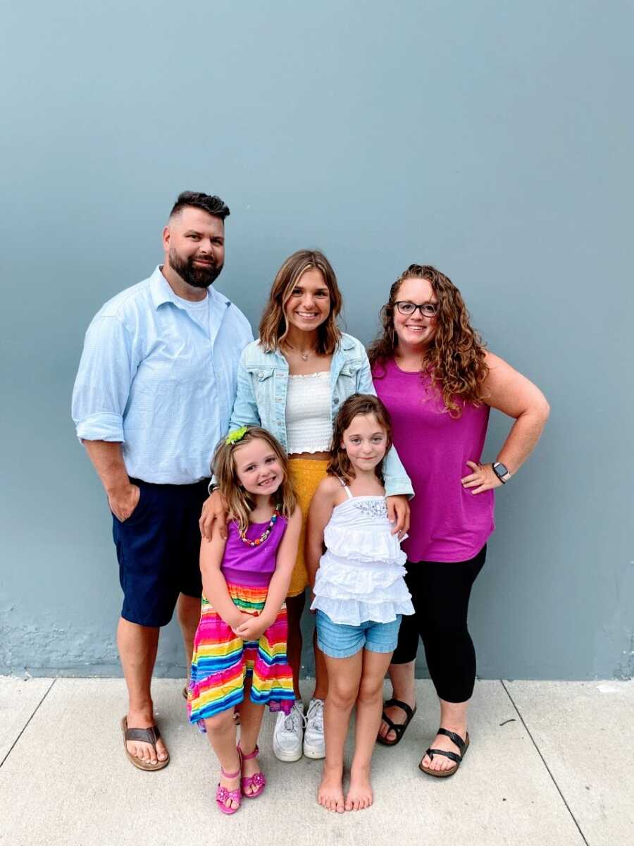 Mom and stepmom takes a photo with her husband and three daughters 