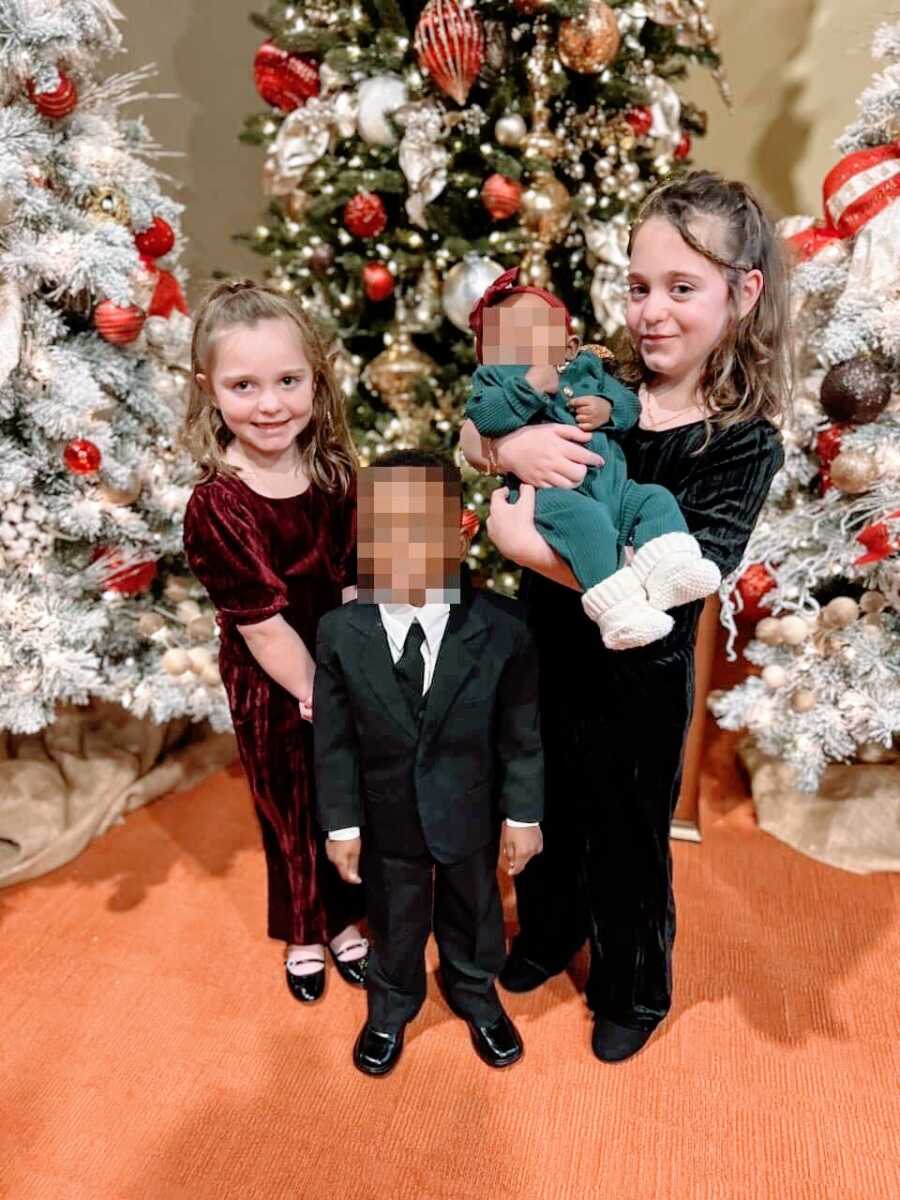 Mom takes a photo of four of her children all dressed up for a Christmas event at church