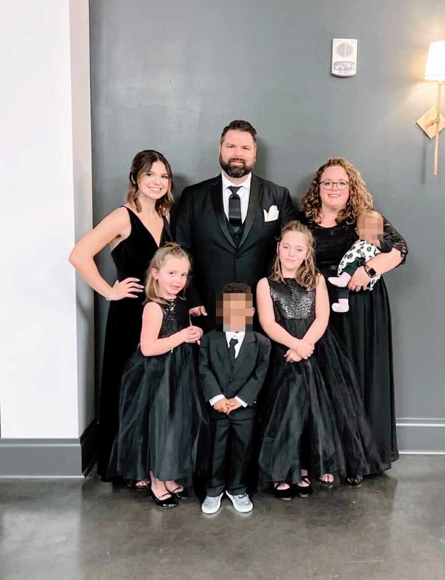 Family of five take a photo with their two foster children while all wearing black outfits for a nice Christmas event