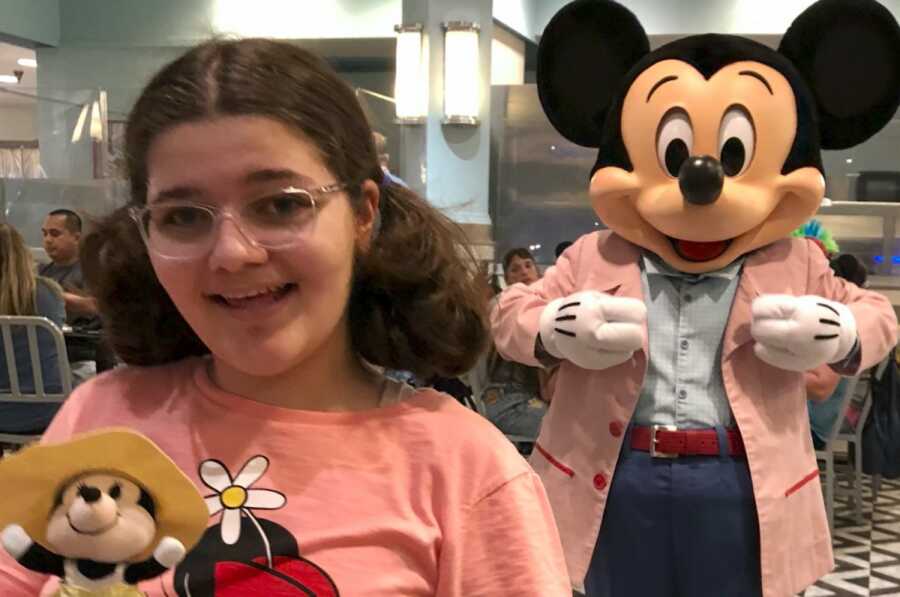 young girl in disney land with mickey mouse