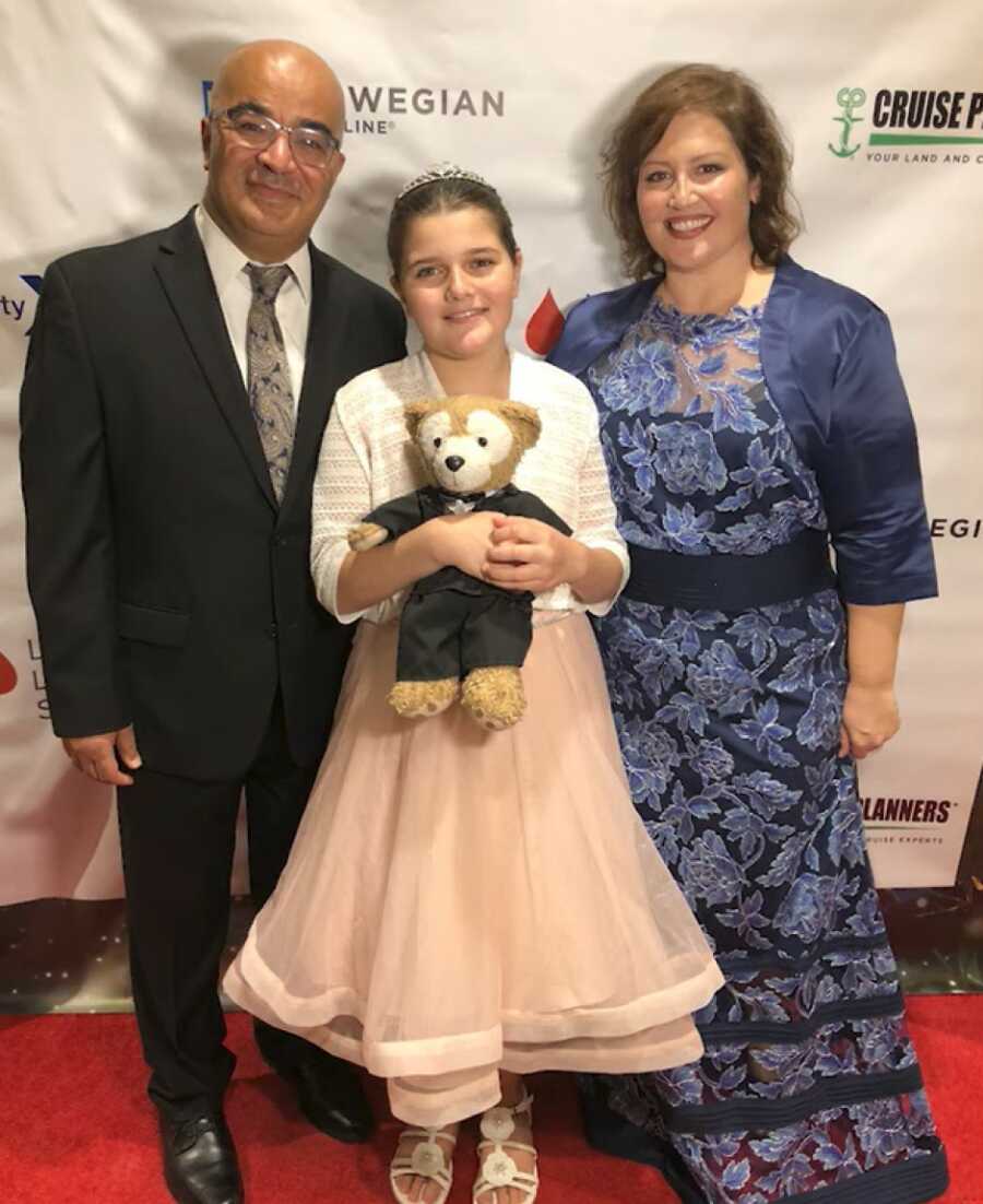 young girl with her parents at a ceremony 