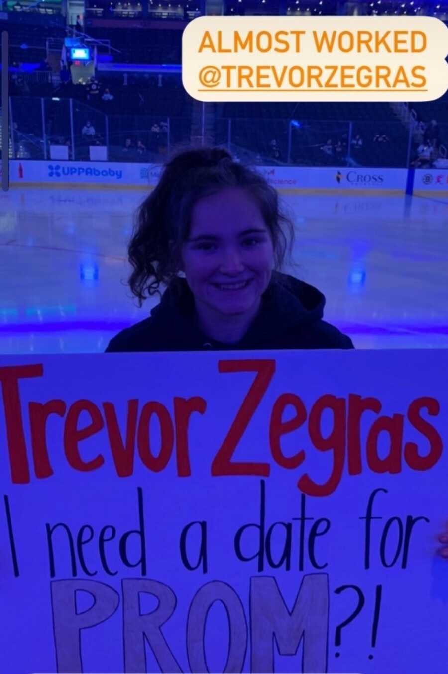 girl holding up sign at ducks game