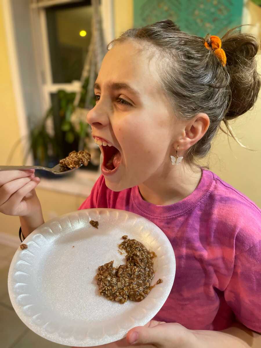 little girl taking a bite of her cookie