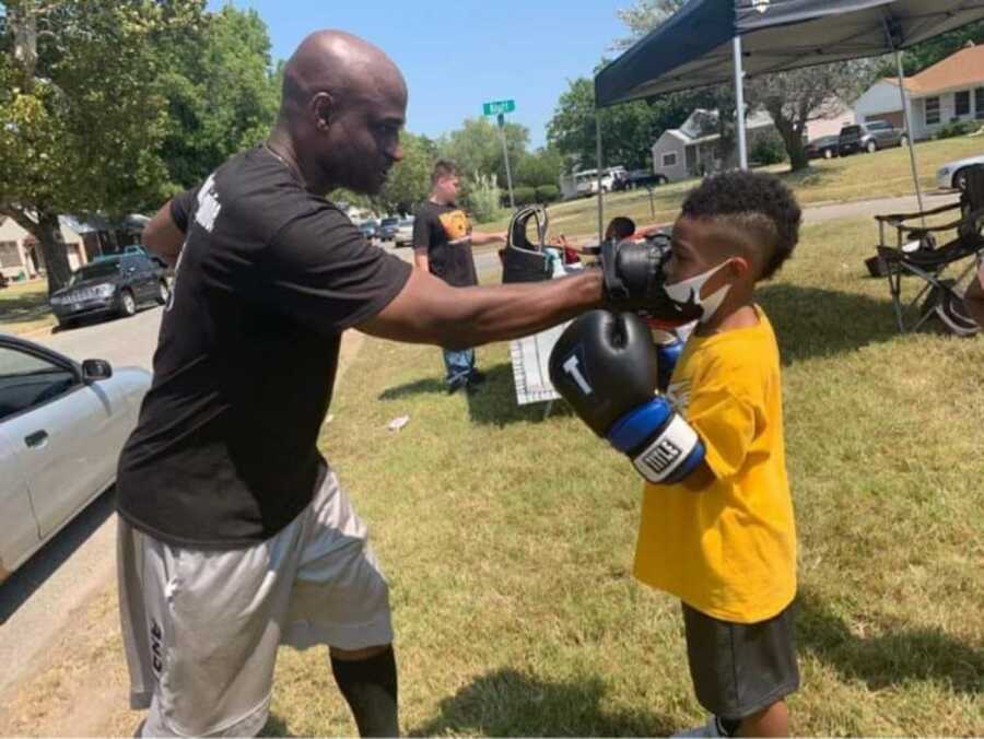 man teaching a kid how to box