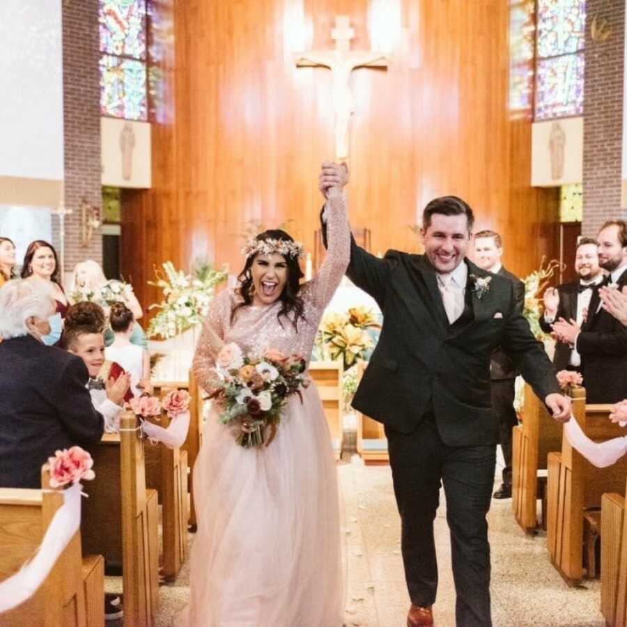 couple walking down the aisle looking happy