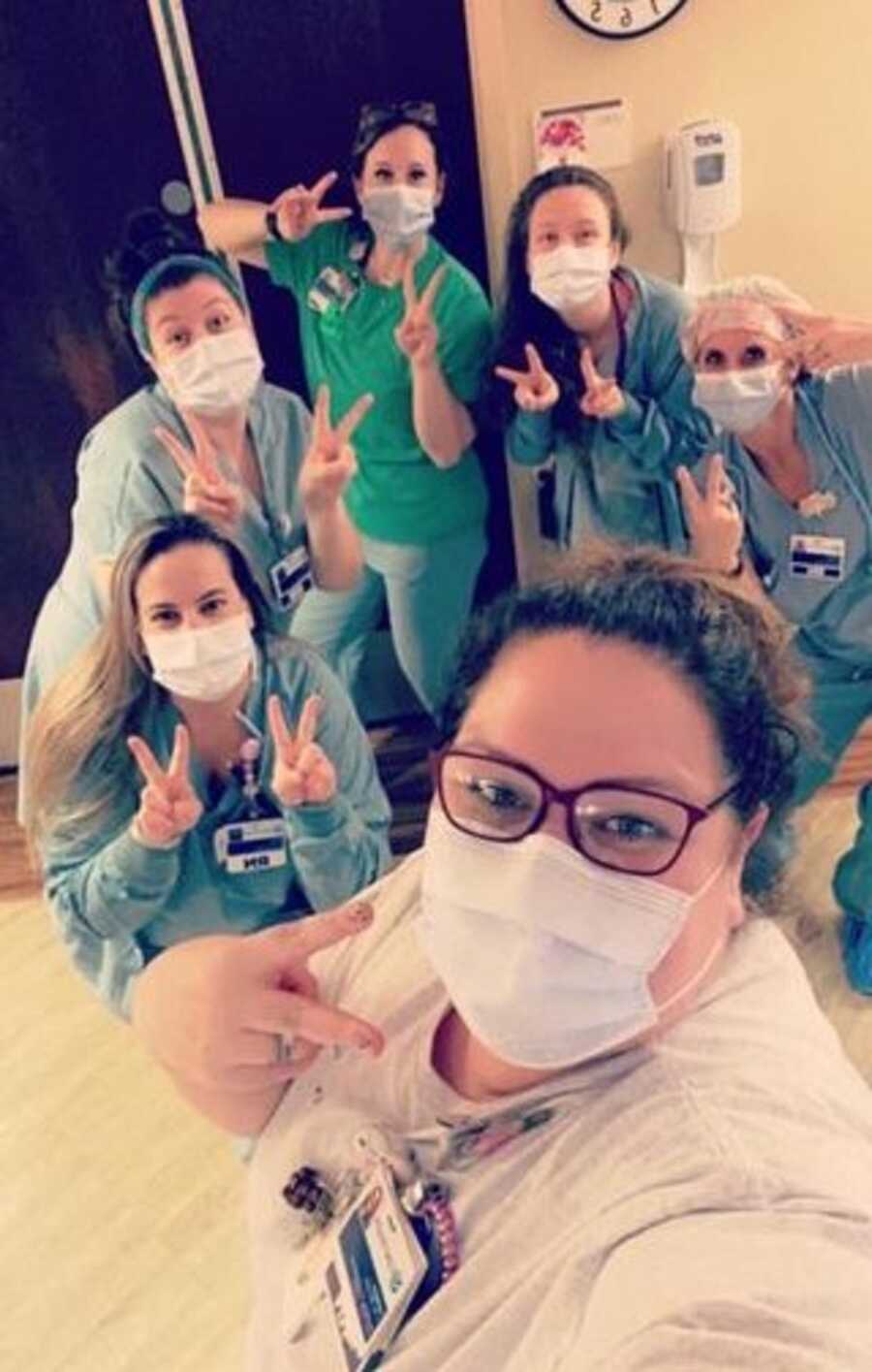 Nurses hold up two fingers for baby born at 2:22 a.m. on February 22, 2022.