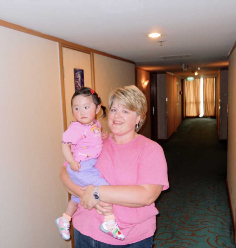 Single mom from Nashville, TN holds Chinese orphan she's adopting. 