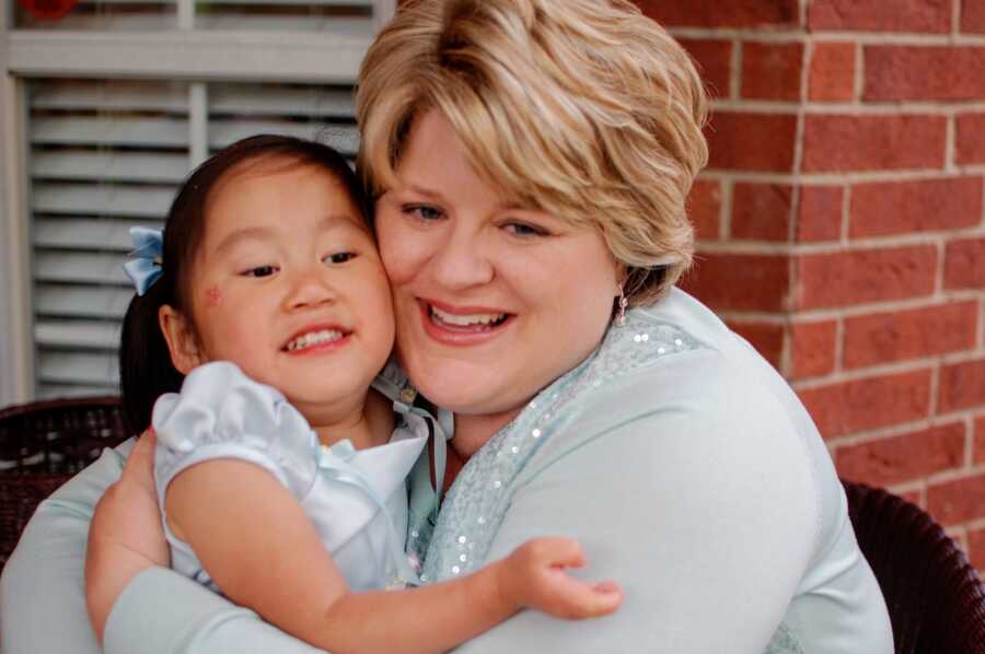 Single adoptive mom and daughter take picture in matching light blue church clothes.