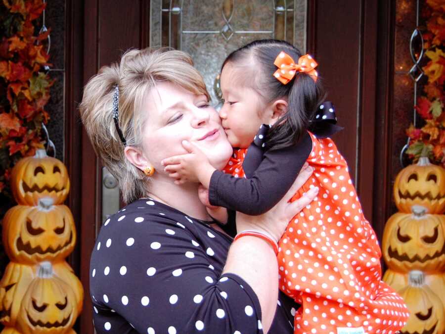 Single adoptive mom and daughter take cute Halloween picture together.