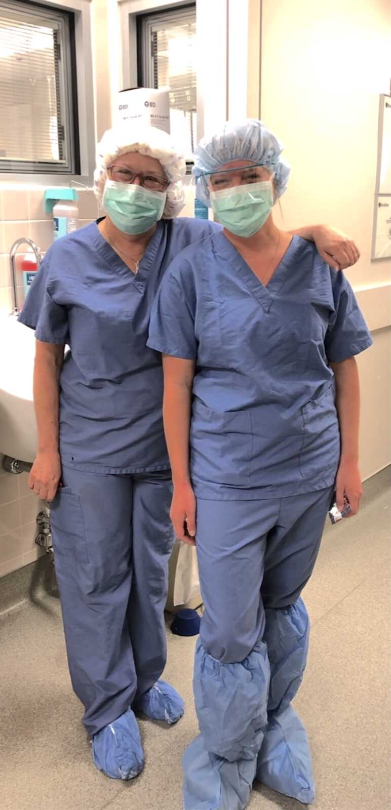 mother and daughter OBGYNs pose together in their scrubs and ppe