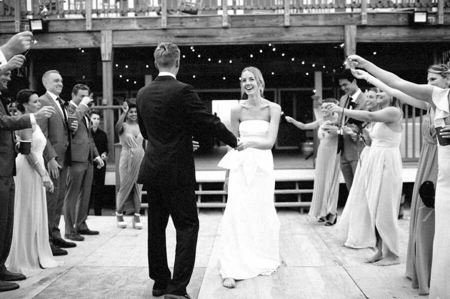 Husband and wife on their wedding day surrounded by friends and family