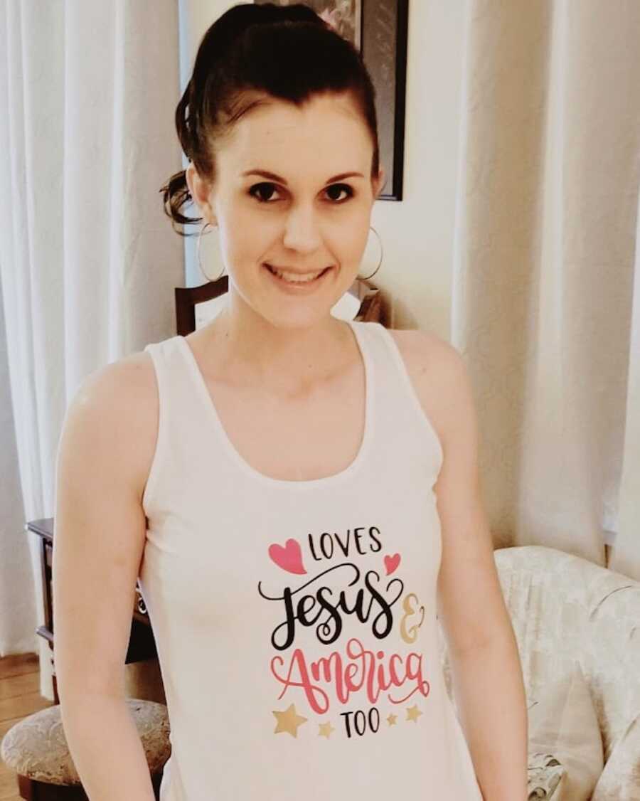 Duchenne mom poses smiling wearing a shirt that shows of her faith