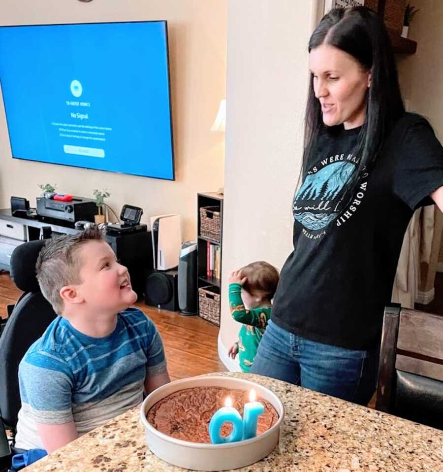 Duchenne mom looks at her son in a wheelchair while singing happy birthday