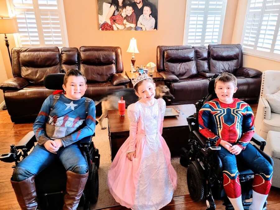 three siblings, one girl and two boys with Duchenne's pose in their Halloween Costumes