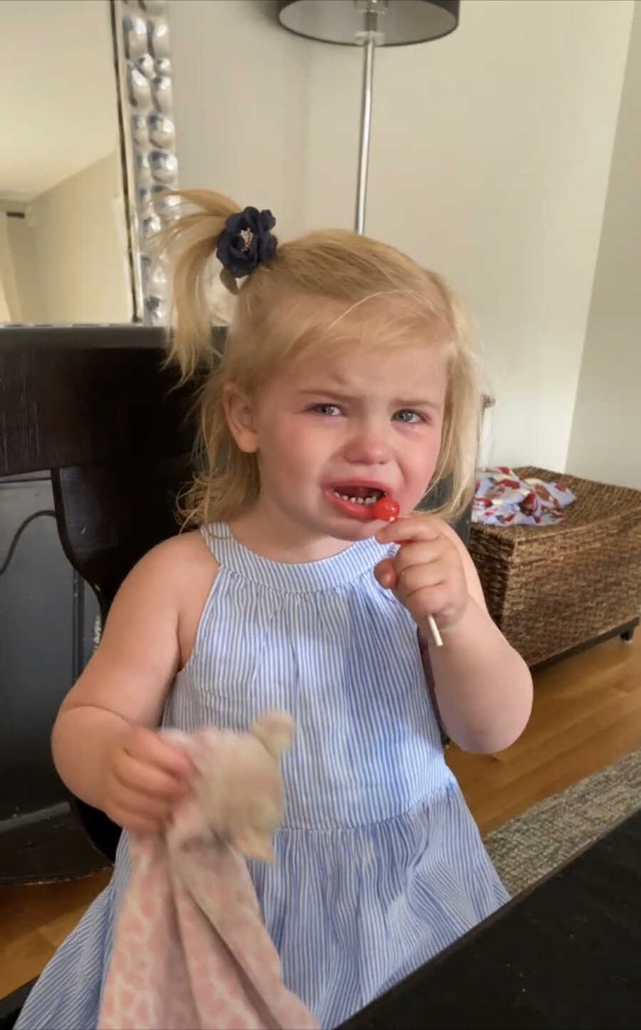 little girl upset eating a piece of candy