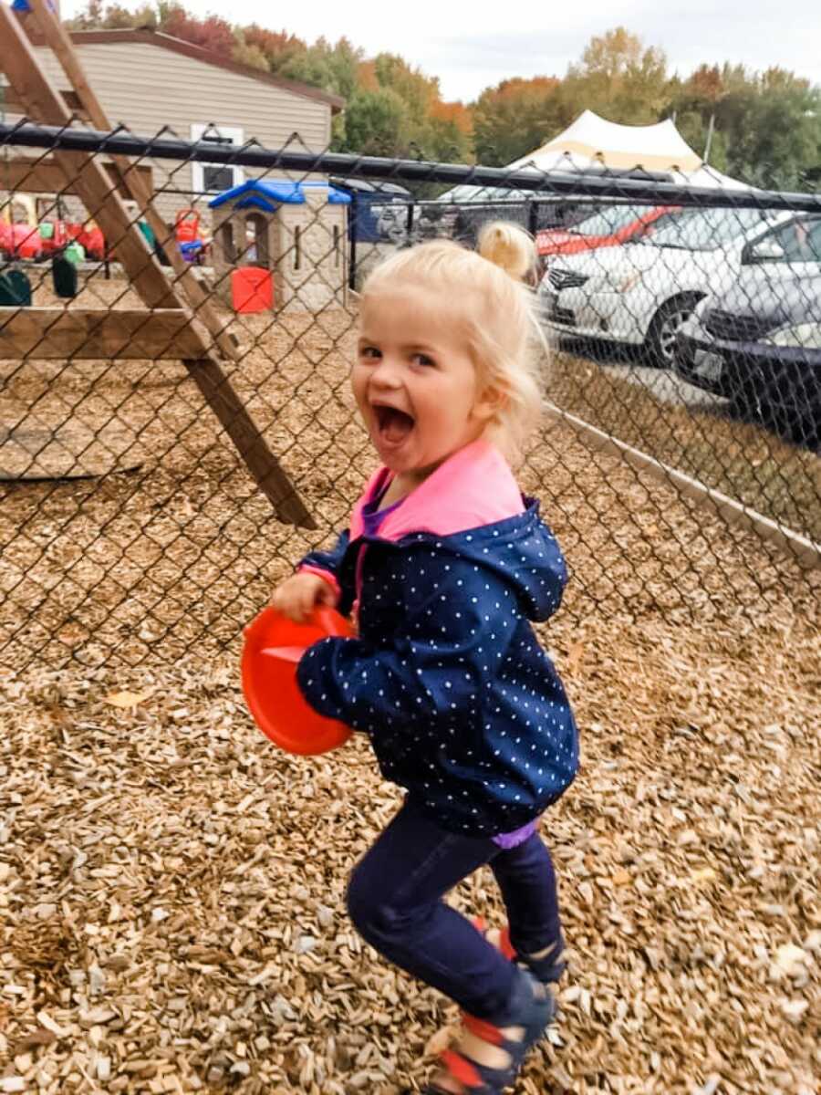 little girl running around in the woodchips