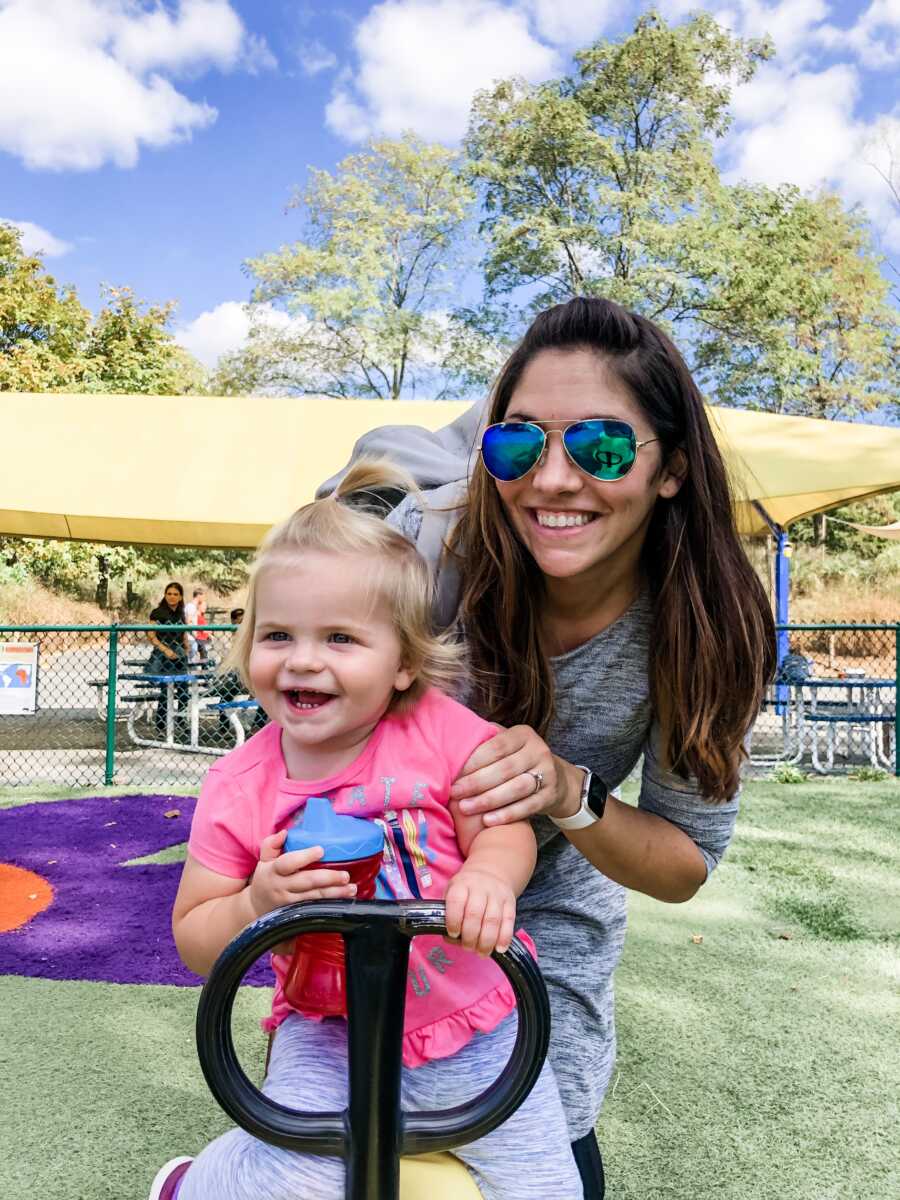 mom and daughter at play ground s,miling