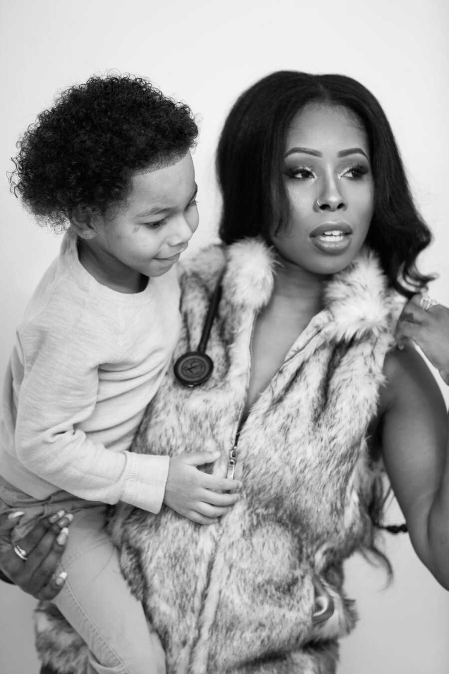 Single mom holds youngest son in stunning black and white photo.